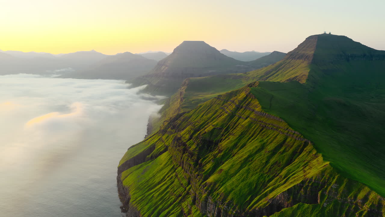 Dramatic Coastal Landscape with Green Mountains and Foggy Ocean at Sunrise