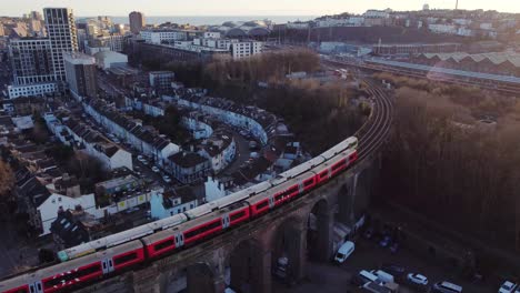 two trains pass each other on brighton viaduct, sea in background, drone shot.
