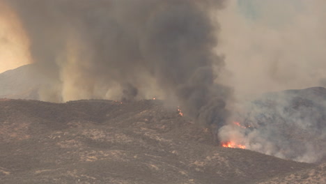 Aerial-view-of-dark-smoke-rising-to-sky-during-nature-wildfire-in-in-America