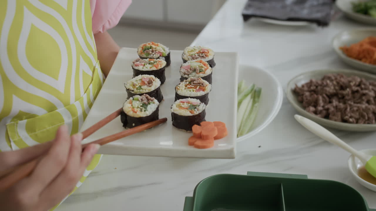 Hands of Girl Putting Self-made Kimbap in Lunchbox at Kitchen