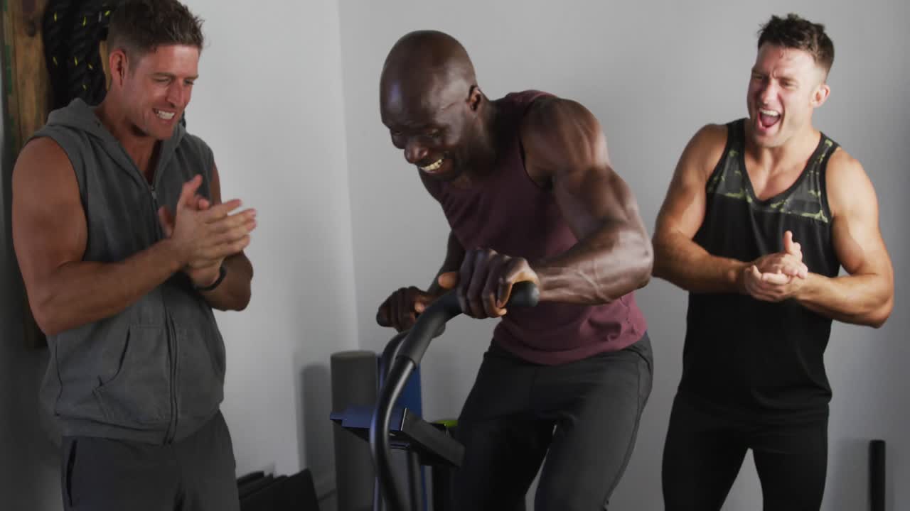 grupo diverso de tres hombres en forma cruzan el entrenamiento dentro del gimnasio