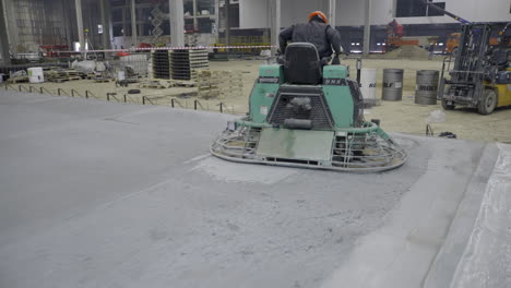 concrete floor finishing with power trowel in industrial building