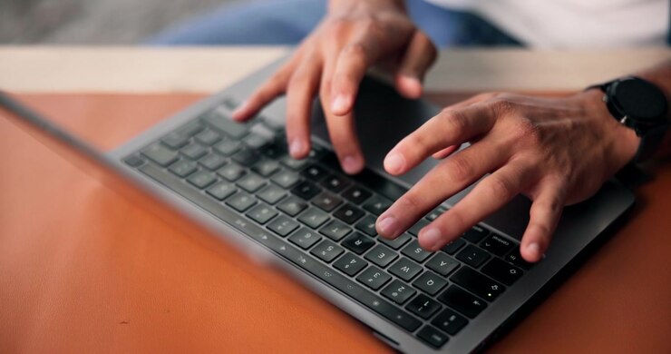 Close-up of Person Typing on Laptop Keyboard