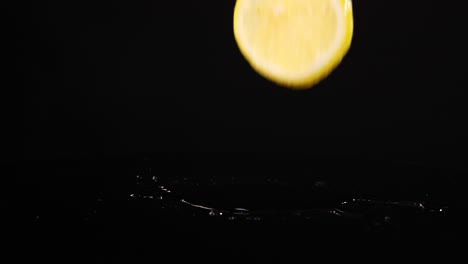 lemon slices fall onto a reflective wet surface, creating splashes against a dark background in slow motion