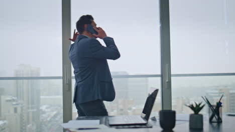 mad manager screaming cellphone gesturing hands yelling at workplace back view