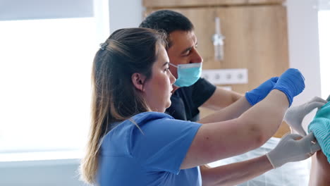 medics giving epidural anesthesia to a pregnant patient. doctor and nurse attach tubes to a woman's back.