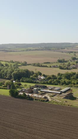 straight aerial descent over rolling english farmland with fields and scattered trees