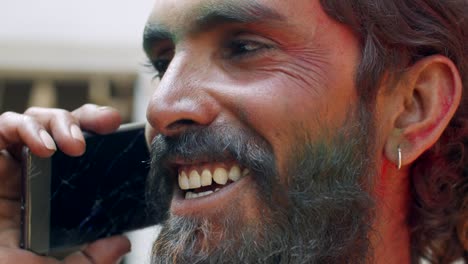 indian man close-up of face smeared with bright holi colors