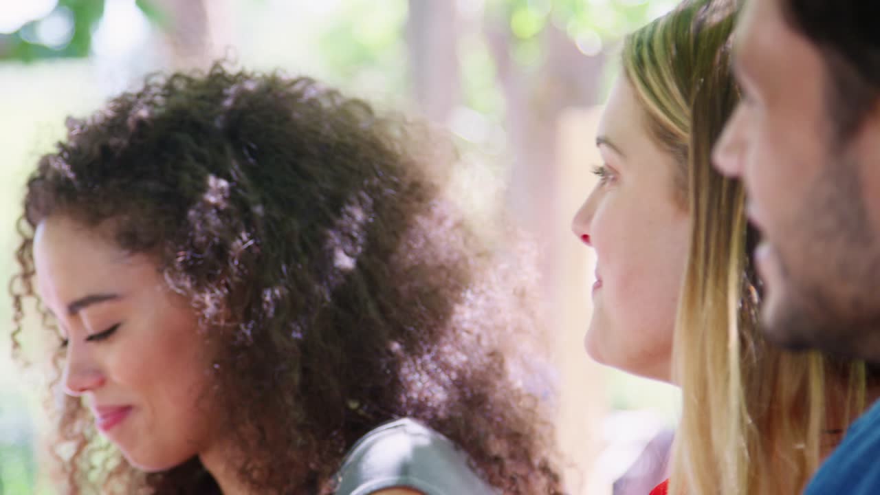 정원에서 테이블에서 사교하는 세 명의 친구