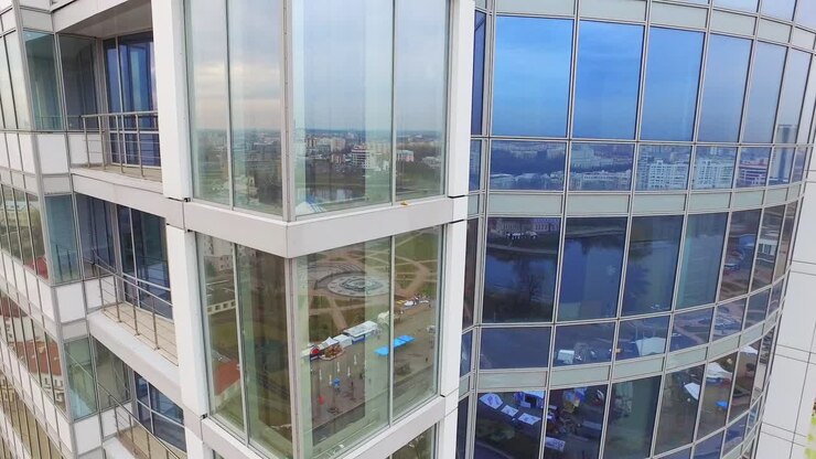 Riflesso della città nelle finestre a vetro di un edificio commerciale. Edificio del centro direzionale