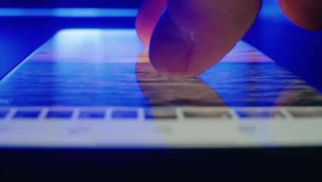 closeup of young man hands scrolling phone gallery images at night