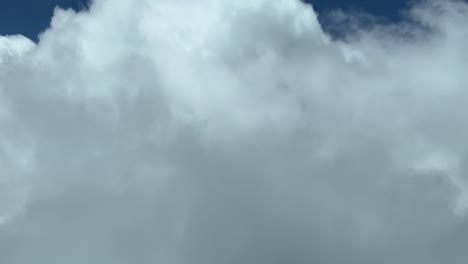 volando a través de un cielo lleno de nubes durante un vuelo real a 9000 m de altura con un cielo azul profundo