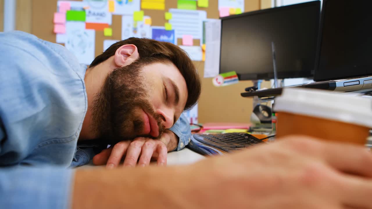 Male graphic designer sleeping at desk