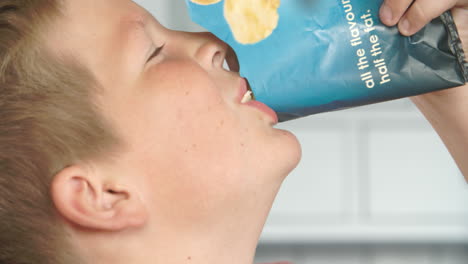 close up de un niño comiendo un paquete de papas fritas