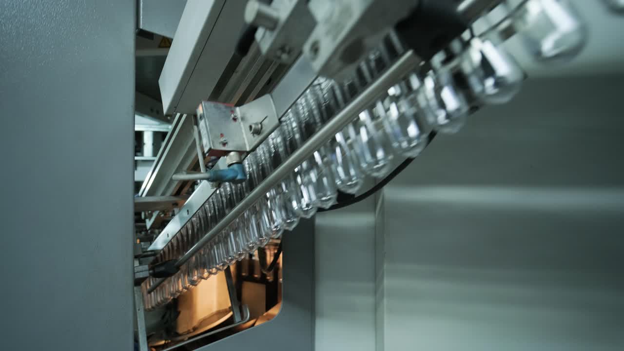 Automatic filling machine pours water into plastic PET bottles at modern beverage plant