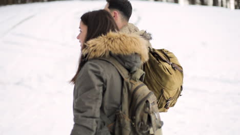 Caucasian-couple-hiking-on-a-snowed-forest.