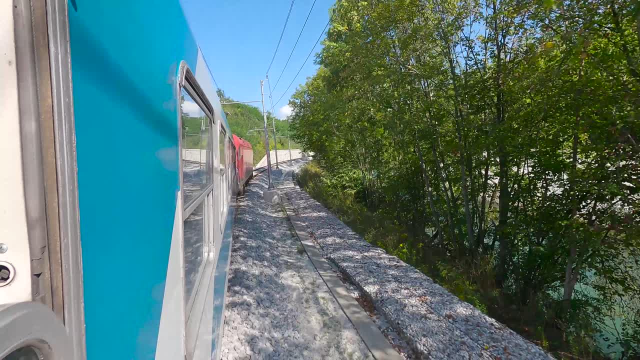 tren de pasajeros en eslovenia saliendo de ljubljana por un río, cámara a bordo