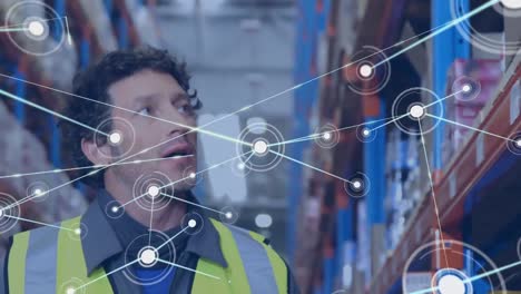 Animation-of-network-of-connections-over-caucasian-male-worker-checking-stock-at-warehouse