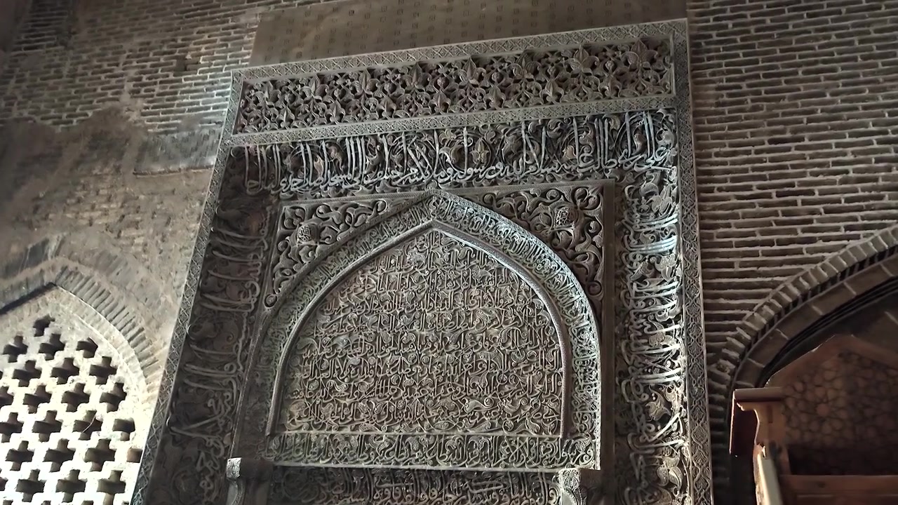 Intagli in pietra intricati su antico mihrab di moschea