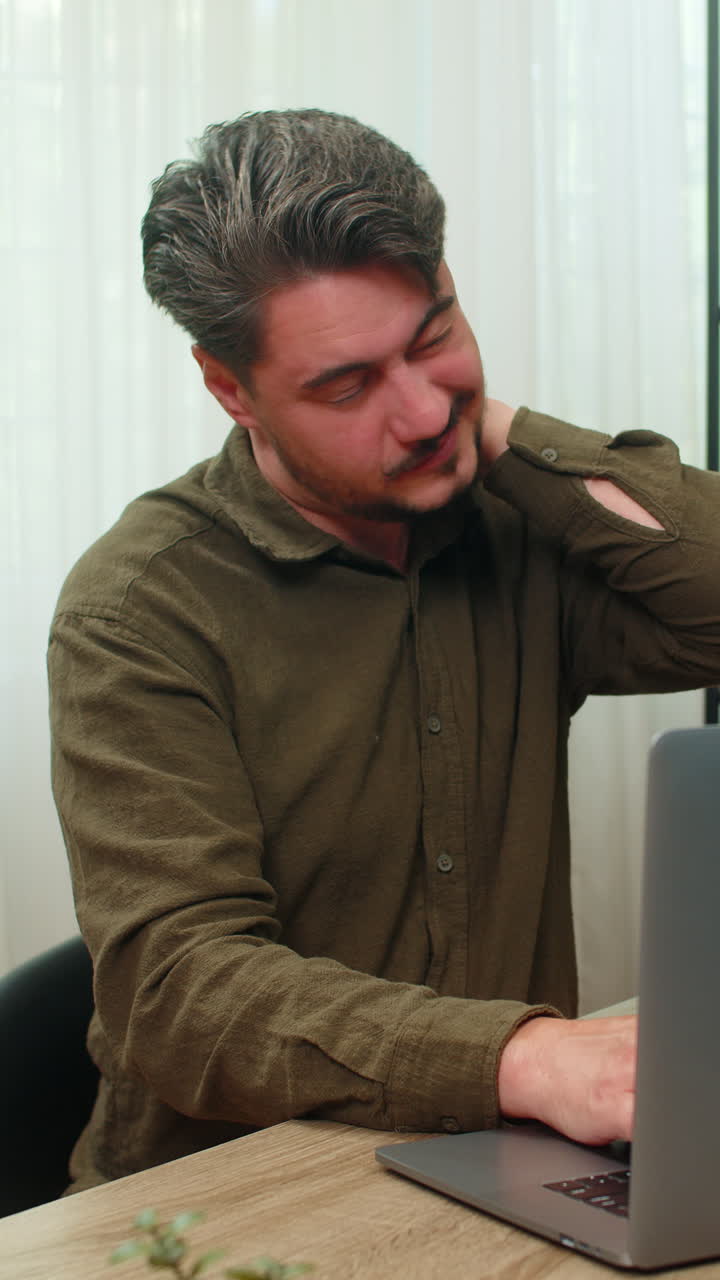 Middleaged man massages neck closing laptop frustrated bad pain strain after work fatigue at table