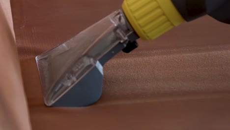 close up of the nozzle of a deep cleaning machine at work where the dirty liquid passes through the sight glass