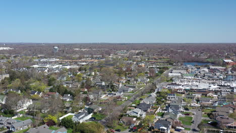 an aerial drone shot over a quiet suburban neighborhood on a sunny day on long island, ny