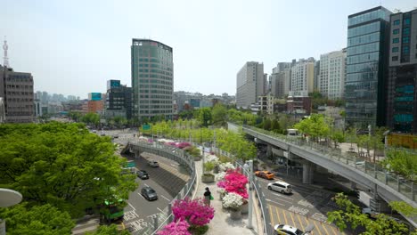 the seoullo 7017 skygarden with pedestrians, trees and flowers on an elevated, linear park above the highway