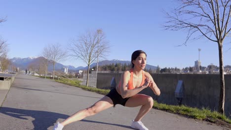 Joven-Mujer-En-Forma-Lateral-Dividida-En-Cuclillas-Ejercicio-Al-Aire-Libre-A-La-Luz-Del-Sol