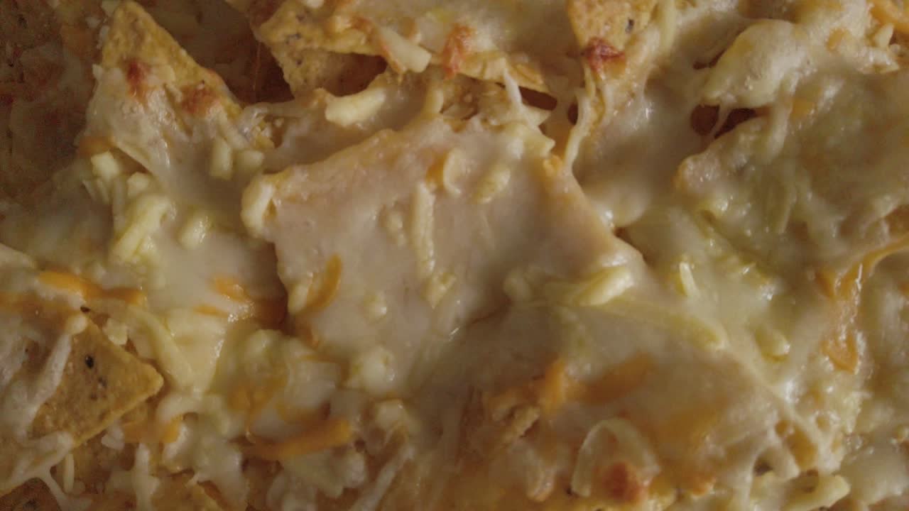 queso mozzarella derretido en nachos con chips de tortilla, primer plano de detalle