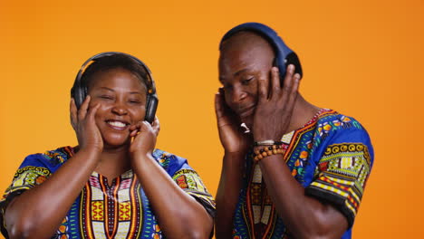 ethnic married couple listening to songs on camera