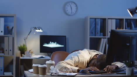 young white collar male worker sleeping on his workplace during night shift, then waking up and starting to work fast while nobody seeing