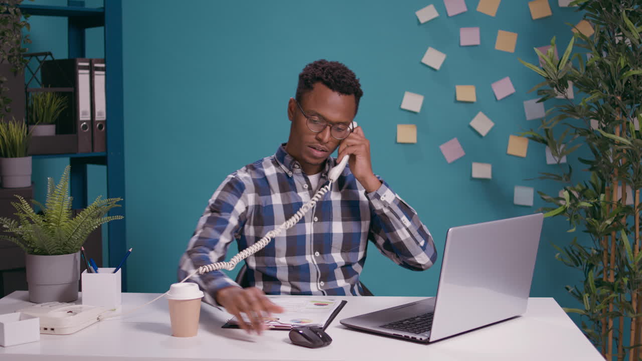 Male operator answering landline phone call in office