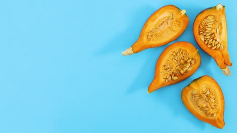 las rebanadas de calabaza madura aparecen en el lado derecho del tema azul. detenga el movimiento