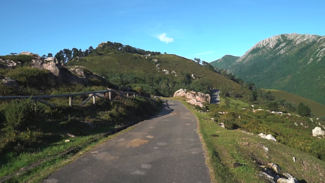 짐벌로 슬로우 모션으로 촬영된 작은 산길을 따라 자동차가 움직이고 있습니다.