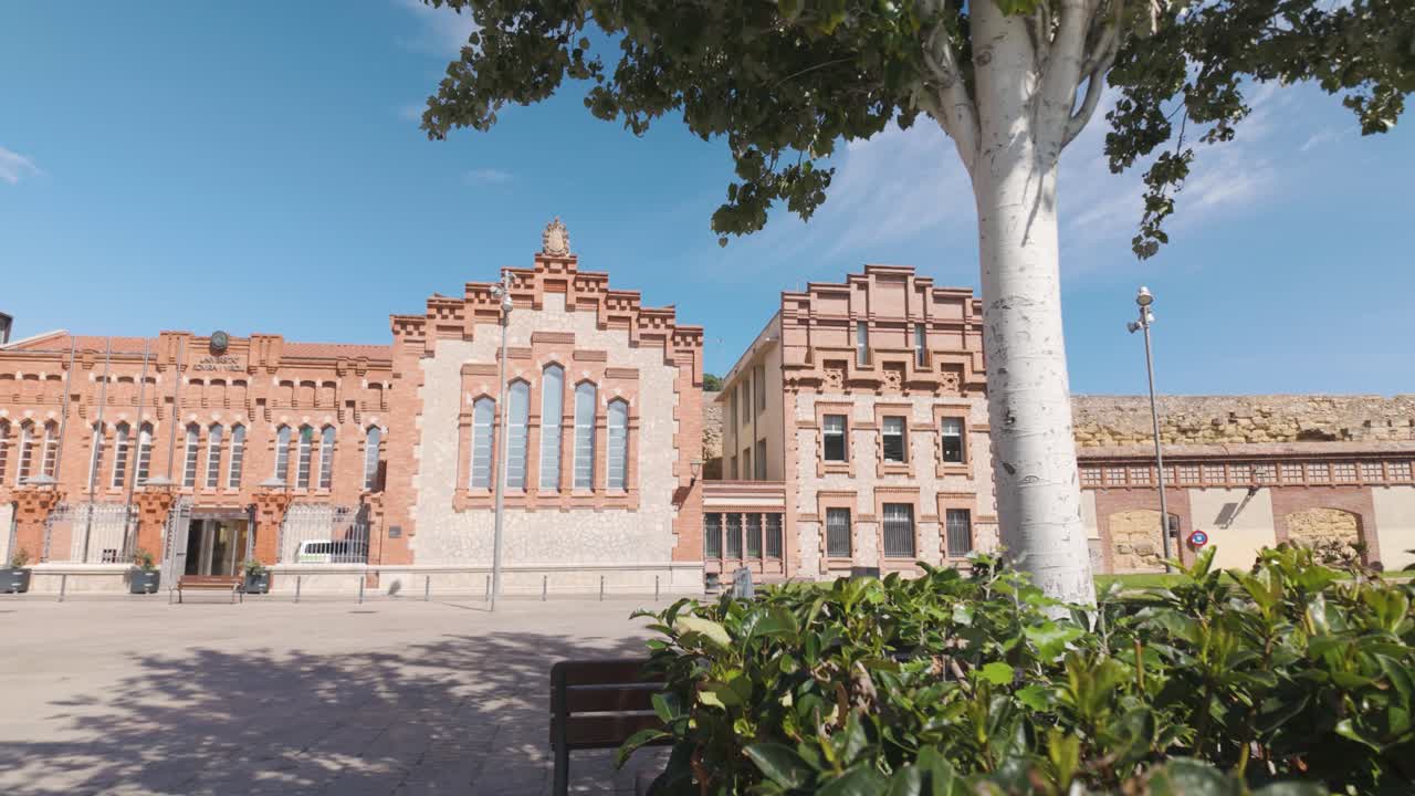 Red brick and stone facade of the University of Rovira i Virgili under a clear sky in Tarragona Spain