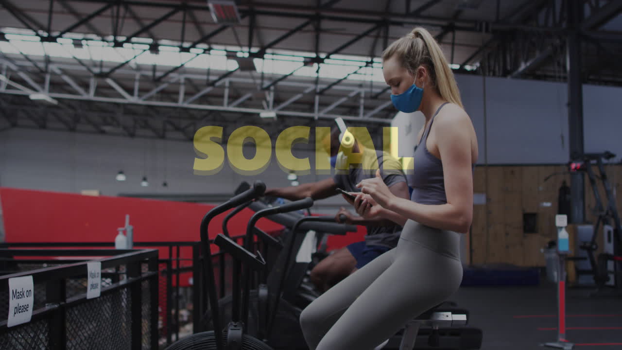 체육관에서 스마트폰을 사용하여 얼굴 마스크를 쓰는 백인 여성에 대한 사회적 거리두기 문자