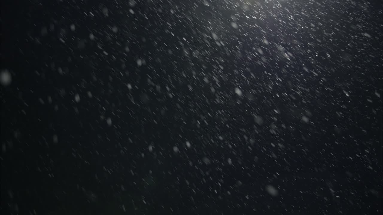 밤에는 겨울의 눈이 내리며 거리 조명에서 도시 거리에서 눈이 내린다.