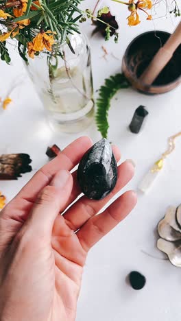 hand holding a black and white fossil crystal