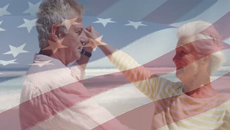 animación de una feliz pareja caucásica senior bailando en la playa sobre la bandera de los estados unidos de américa