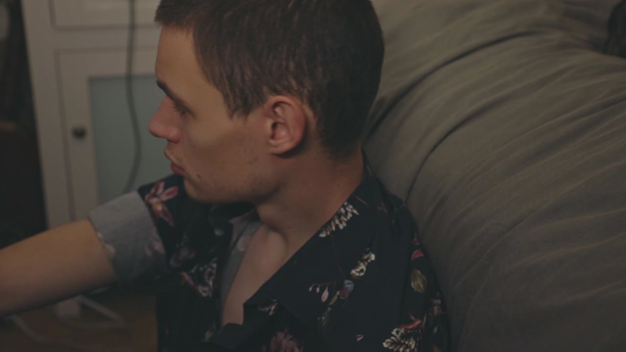 Young Upset Man Sitting On A Couch In Deep Thoughts - Closeup Shot
