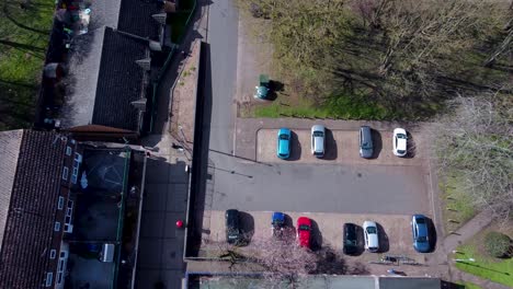 aerial drone top down shot of a parking lot with cars amidst lush vegetation on the outskirts of a forest in thetford, united kingdom on a sunny day