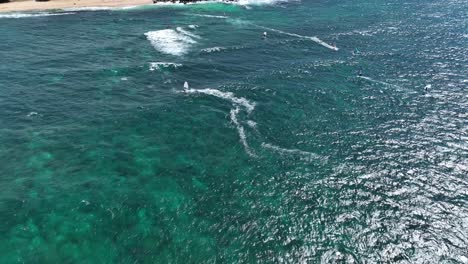 Windsurfistas-Y-Wing-Foilers-Cabalgando-Contra-El-Viento-En-Tierra-De-Regreso,-Hookipa-Maui