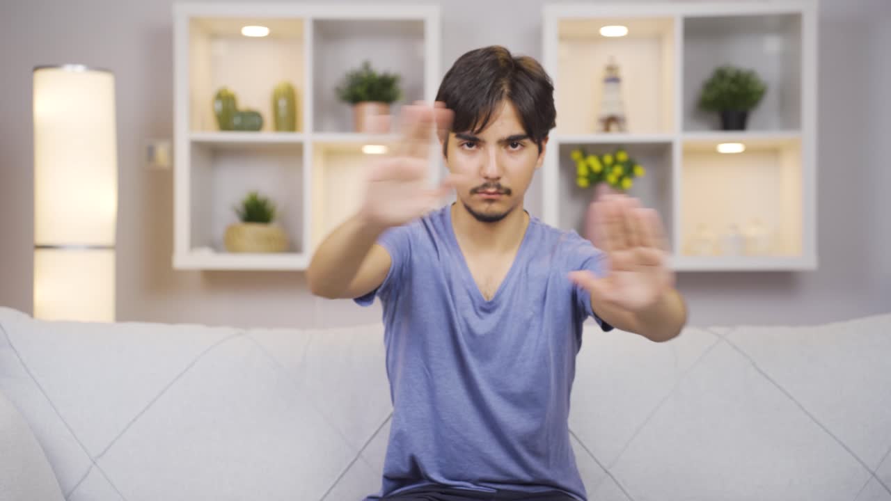 남자가 카메라를 위해 정지 표지판을 만들고 있습니다.