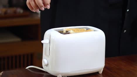 person toasting bread in a toaster