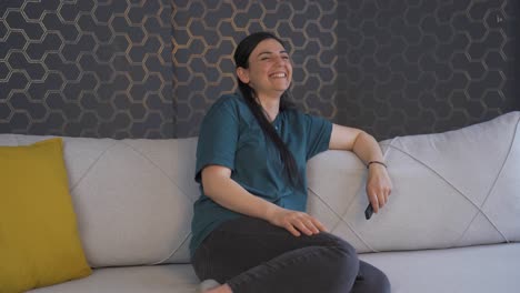 la mujer que ve la comedia en la televisión se ríe.