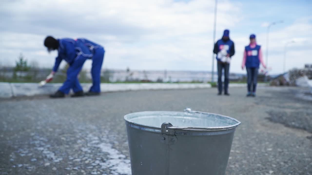 지역 사회 의 자원 봉사자 들 이 거리를 청소 하고 있다