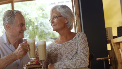 Älteres-Paar-Toastet-Kaffeegläser-Und-Küsst-Sich-Im-Café-4k