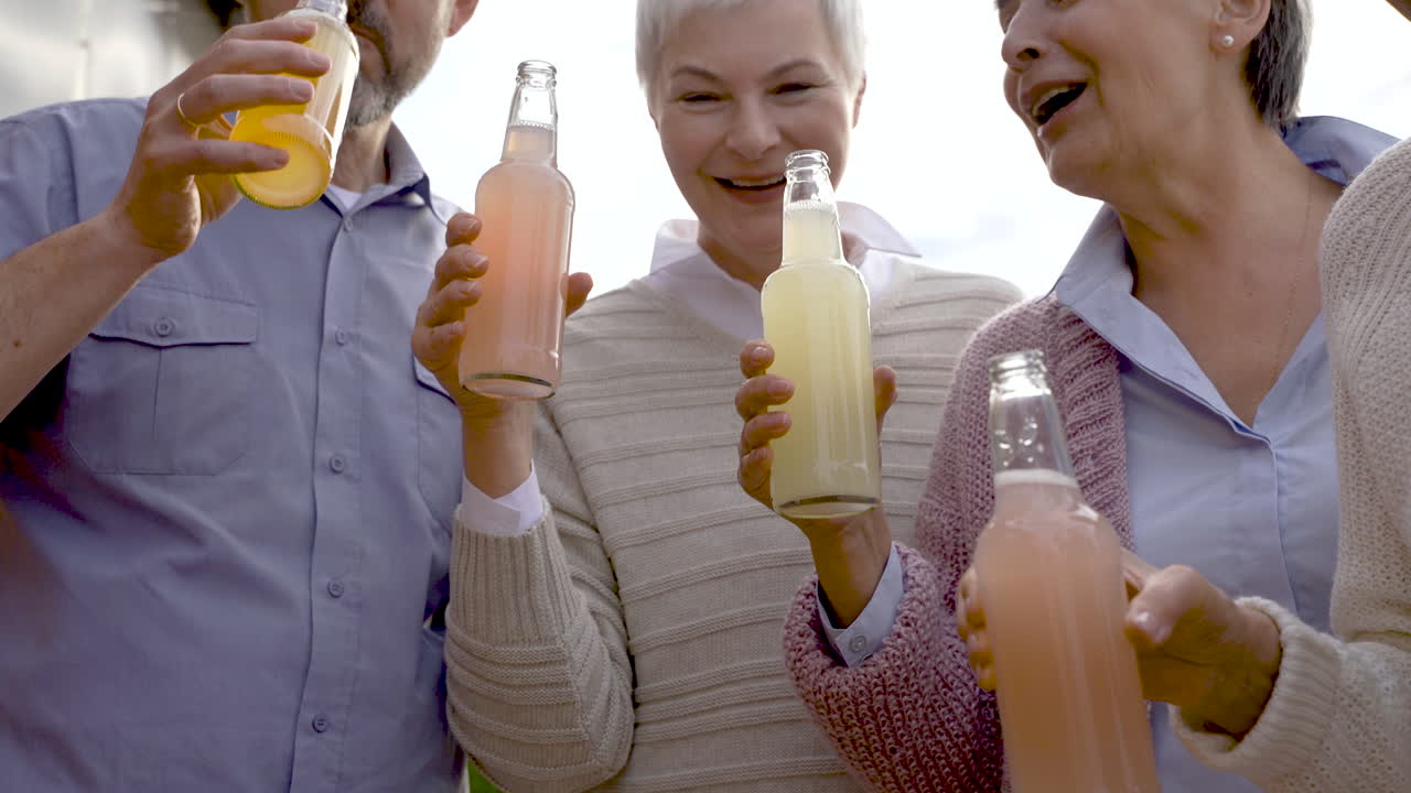 한 무리의 노인들이 춤을 추고 병을 들고 웃고 있다