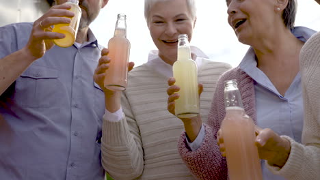 group of senior people dancing, toasting with a bottle and laughing