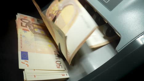 euro banknotes being processed by a counting machine